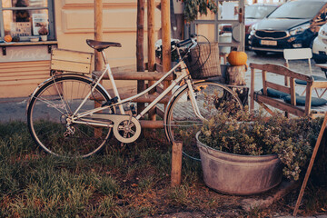 White bicycle parked on grass in front of building