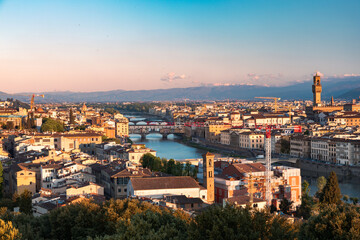 Fototapeta premium Sunrise view of the city center of Florence and the Ponte Veccio bridge from the Vista panoramica di Firenze in Italy during the spring time.