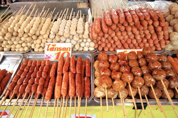 Meatballs,Sausage,Chickenballs on sticks, dipped in sweet chili sauce at a market in Thailand