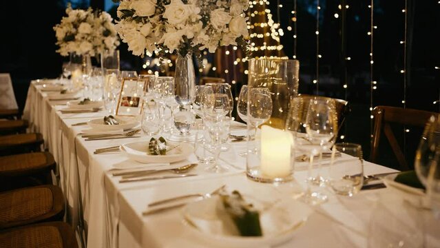 Dinner table setup sunset background. Close up decoration flowers candles Boho style. Romantic wedding reception party outdoor.