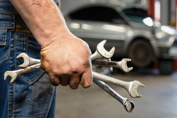 hands of a worker holding wrenches