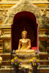 Golden Thai Buddhist Idol statue in Chiang Mai Thailand symbolizing worship at tourist temple.