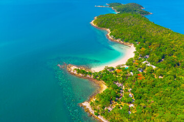 Beach with beautiful coastline. Tropical bay surrounded by coral reefs, aerial top view