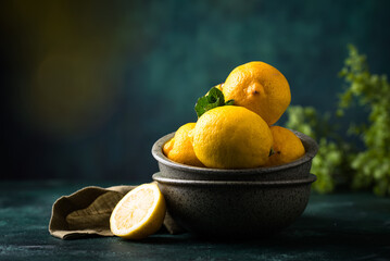 Bowl with lemon on green background