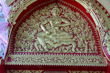 Golden Thai Buddhist Idol decoration  in Chiang Mai Thailand symbolizing worship at tourist temple.