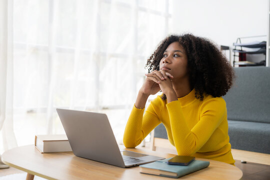 Happy young woman using laptop sitting at desk writing notes while watching webinar. Study online. Look at web learning or have online meeting, distance learning concept. - Powered by Adobe