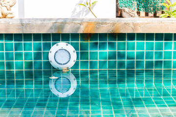 LED swimming pool light on tile wall, underwater illumination installation on concrete wall,...