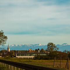 Alpine spring view with a church and the alps in the background near Meersburg, Lake Bodensee, Baden-Württemberg, Germany