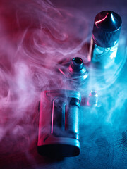 Modern vaping device, kit with an evaporator, cartridge and nicotine liquid. Multi-colored smoke.