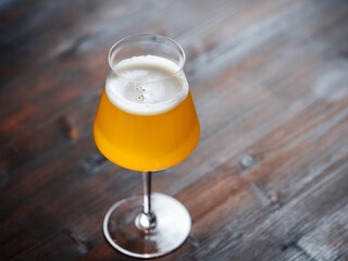 Craft beer in a Teku glass on a wooden table. copy space