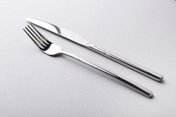 Stylish cutlery. Silver knife and fork on gray background