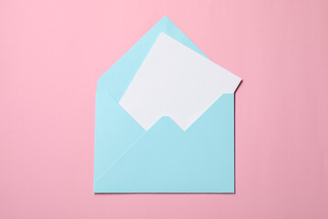 Letter envelope with card on pink background, top view