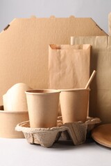 Eco friendly food packaging. Paper containers, tableware and bag on light background