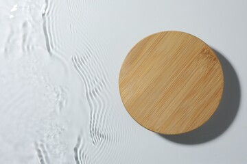 Presentation of product. Wooden podium in water on white background, top view. Space for text