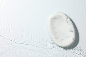Presentation of product. Marble podium in water on white background, top view. Space for text