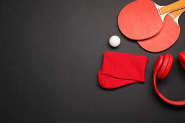 Sports equipment. Ping pong rackets, ball, headphones and socks on black background, flat lay....