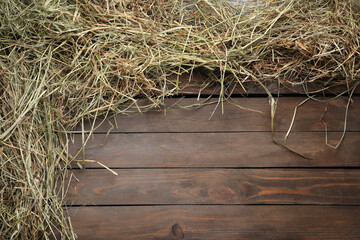Frame made of dried hay on wooden table, top view. Space for text
