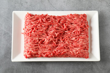 Raw ground meat on grey table, top view
