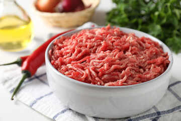 Raw ground meat in bowl on table, closeup