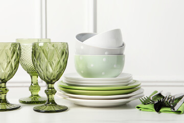 Beautiful ceramic dishware, glasses and cutlery on white table