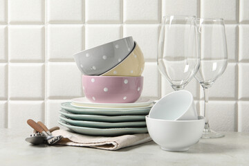 Beautiful ceramic dishware, glasses and cutlery on light grey table