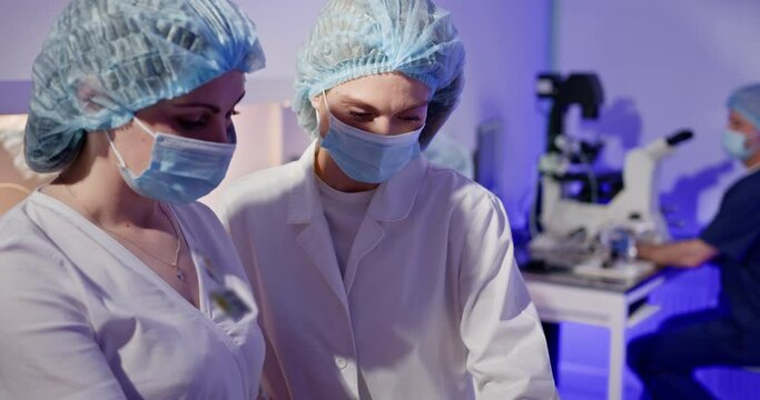 Embryologists conducting artificial fertilization of human eggs in a laboratory, showcasing precision and advanced reproductive technology. Embryologists Performing Artificial Fertilization