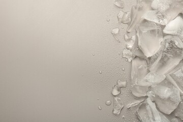 Pieces of crushed ice on grey background, top view. Space for text