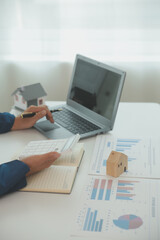 Fototapeta premium Businessmen holding pens, signing home titles with insurance, care about real estate services and the idea of real estate agents offering interest in installments to their customers.