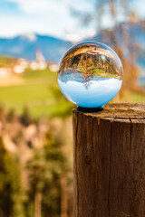 Crystal ball alpine spring landscape shot with a church in the background seen from near...