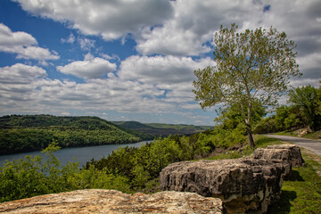 Overlook at Table Rock Lake, Holiday Island, Arkansas.
Image contains large boulders, trees, mountains, water.