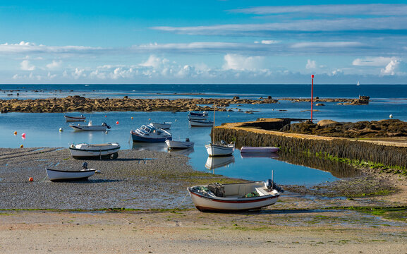 A yellow stone pier jutting out into the blue sea. Point Penmarc'h, Brittany, France.