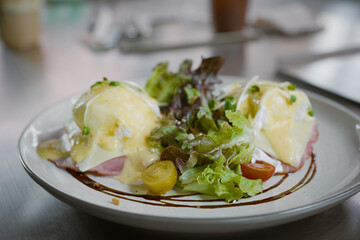 Egg benedict sandwiches in white plate. - muffin with poached egg, ham 
