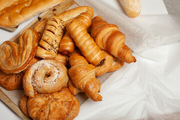 Collection of cakes and different pies with cheese, apple, cherry, meat and cabbage on a plate.