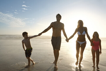 People, holding hands and silhouette on beach in outdoors at sunset for vacation, holiday or...
