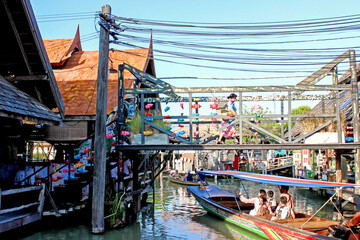 Vivid floating market with traditional boats and structures showcases Thai culture and commerce