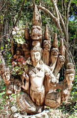 ancient statue in a jungle filled with lush greenery, Thailand