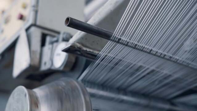 Operation of a flat-slot extruder in the production of polypropylene bags. Close-up of cut threads.