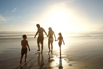 Family, beach and holding hands by ocean for holiday, vacation and summer together in silhouette....