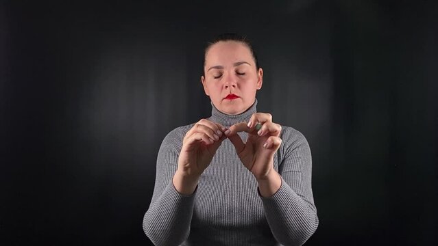 A portrait of a young woman inserting earplugs on a black background. Hearing protection and personal care, capturing a moment of precaution and comfort in a sleek, focused setting