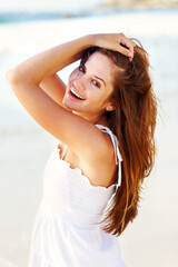 Naklejka premium Portrait, beach or happy woman on vacation to relax on outdoor holiday for break or paradise in Ibiza. Tourist, girl or female person with smile at ocean, nature or sea with peace, wellness or travel