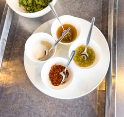 Spices with spoons in a white plate