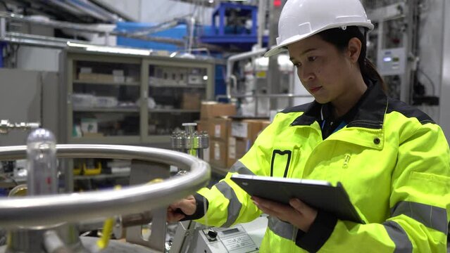 A Factory Engineer Checking Liquid Helium Levels in Storage Tanks, Ensuring Safety Compliance and Recording Usage for Machinery Operations in the Facility