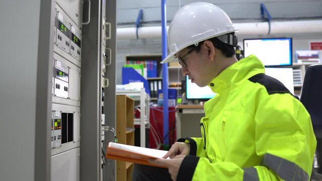Electrical engineer inspects high-voltage electrical cabinet,Technician maintains the factory's electricity meter.