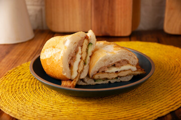 Mexican Torta de Milanesa. Sandwich made with bolillo bread, telera or baguette, split in half and filled with various ingredients, in this case breaded chicken meat with Oaxaca cheese.