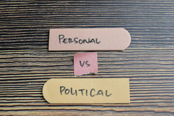 Concept of Personal vs Political write on sticky notes isolated on Wooden Table.