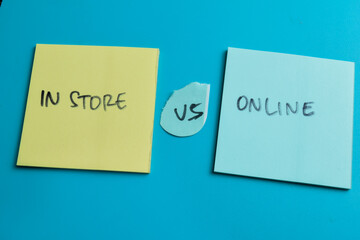 Concept of In Store vs Online write on sticky notes isolated on Wooden Table.