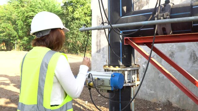 A female engineer working at a water treatment plant, inspecting and maintaining the water supply system, checking chlorine levels, ensuring water quality, and overseeing the dynamo motors and control