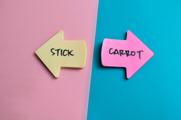 Concept of Stick or Carrot write on sticky notes isolated on Wooden Table.