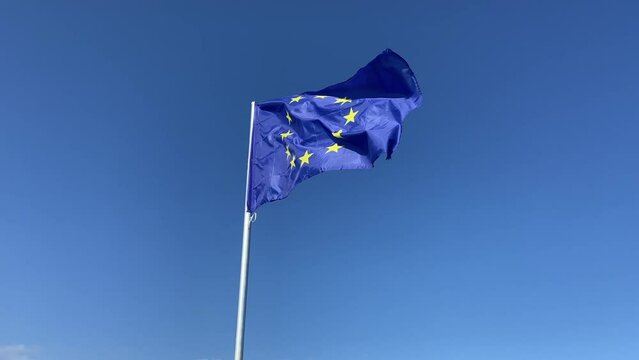 European union flag flutters in the wind on blue sky background, Travel and tourism in European union concept, European parliament elections June 9, 2024