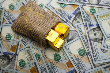 gold bars in a bag on a money background.